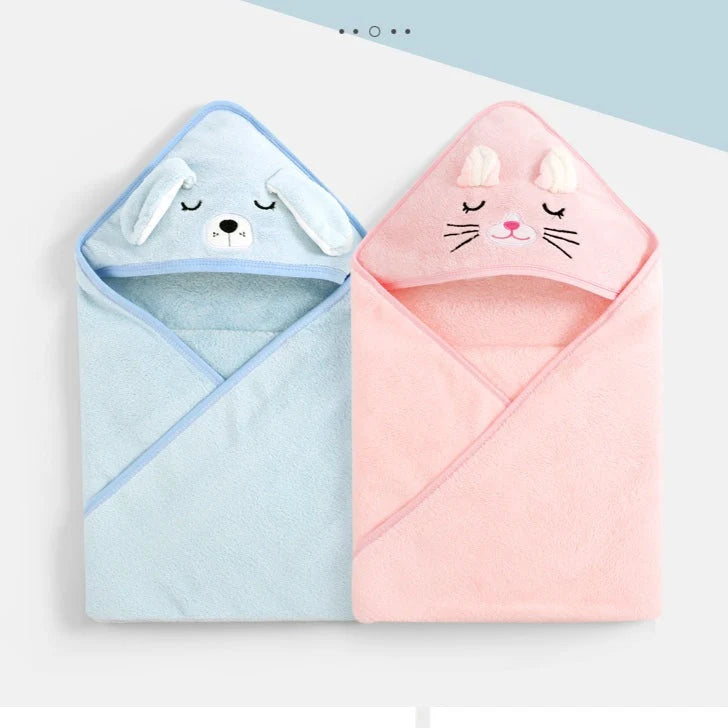 Two plush hooded baby towels shown side by side on a clean white background. The left towel is light blue with a bunny-ear hood and a simple bunny face.